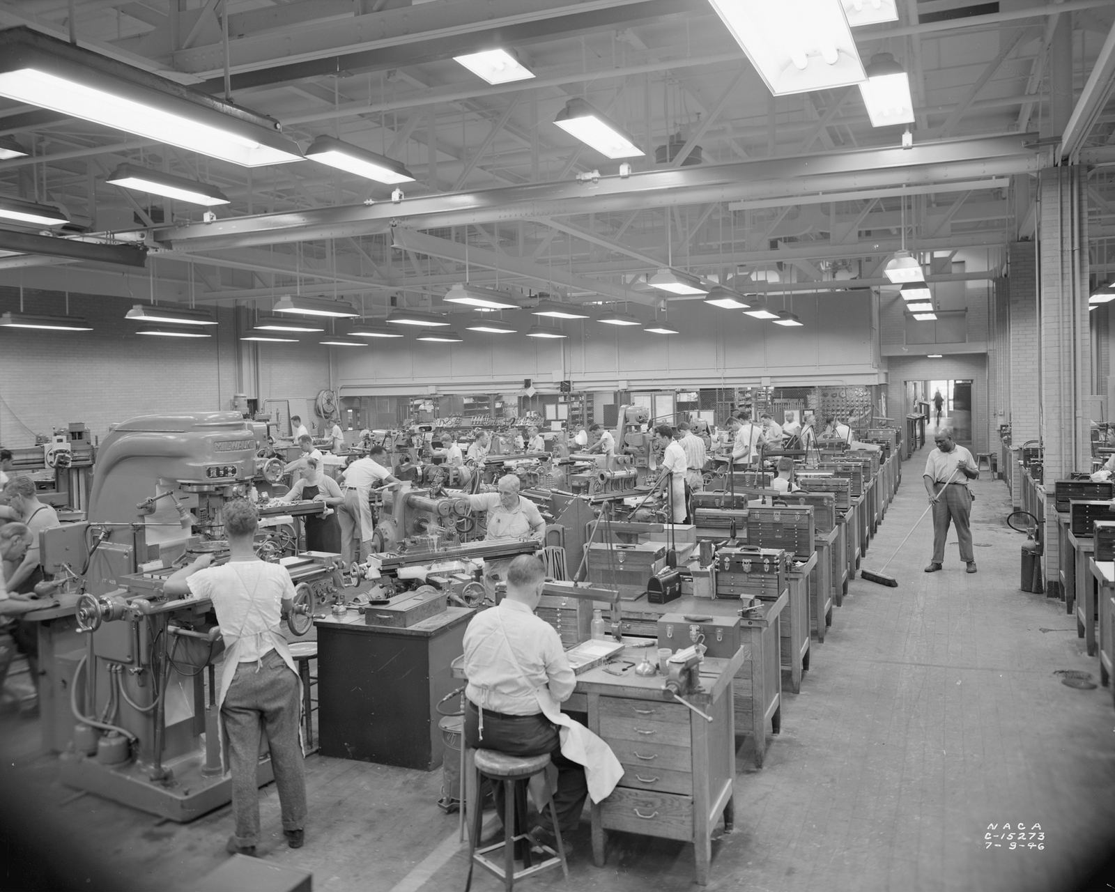 Machinists and toolmakers working with precision machinery on a workshop floor